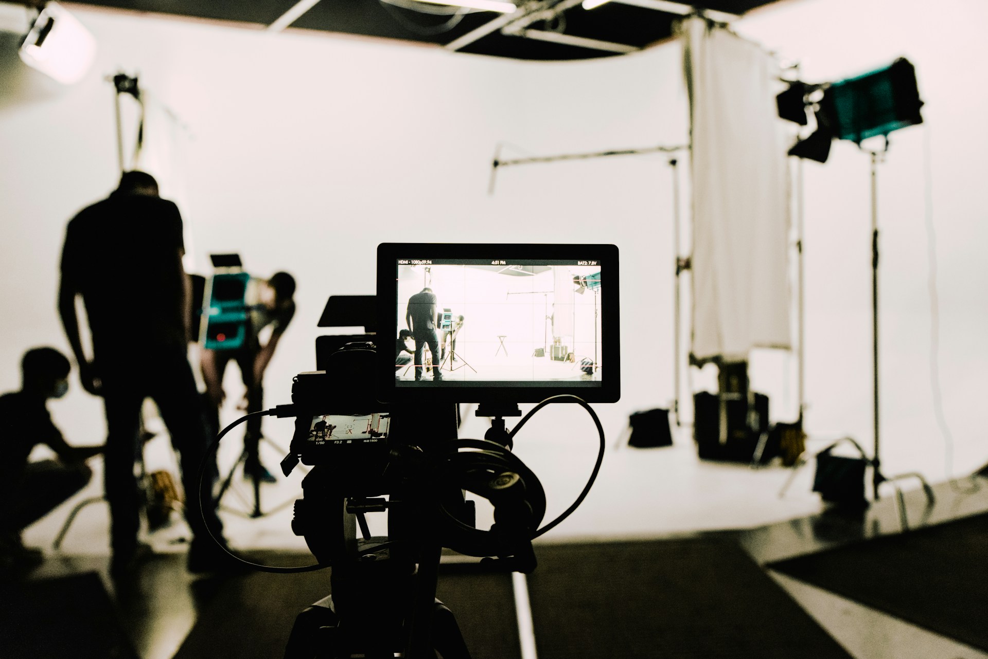 Looking through the viewfinder of a video camera, which is pointed at a studio setup.  Image credit Voyage Pro on Unsplash.